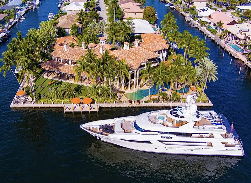 Waterfront estate with a yacht at its private dock, photographed from the air
